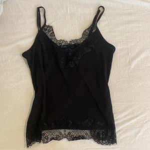 Linne m spetsdetaljer  - Svart linne med spetsdetaljer. Mindre i storlek