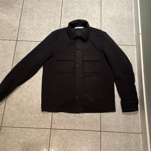 Overshirt Zara - Overshirt från zara i storlek S. Bra skick då den är helt ny (kvitto finns) men några små repor finns men det är inget man tänker på.  Nypris 560kr. (Knapparna går enkelt att byta)   Mitt pris 300kr