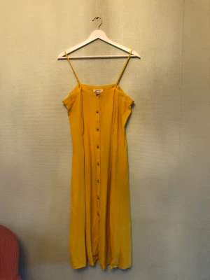 Gul Midi sommarklänning från Other storys - Härlig klänning med knäppning fram och slits