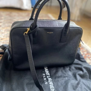 Saint Laurent väska  - Hej, säljer min äkta Saint Laurent (ysl) väska köpt i Paris. Väldigt lite använd utan slitage.   Kvitto finns och det går att få fler bilder.  Modell:  1000/YSL Borsa Museum /8054442905  Storlek:  30x22x8 längd höjd o sid bred