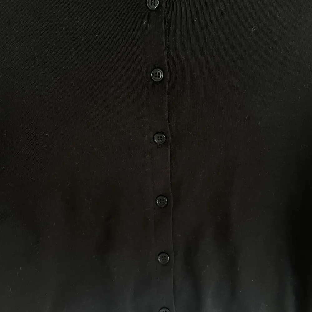 Superfin svart långärmad topp med knappar från H&M i storlek M. . Toppar.