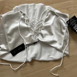 Champagne färgad topp - Jättesnygg topp som aldrig är använd, köptes för 300kr, säljer direkt för 200kr. Lappar finns kvar. Storlek M men skulle säga den mer passar en S. Snöring i ryggen 