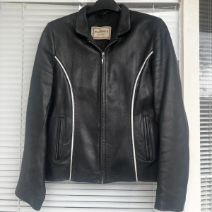 Vintage läderjacka  - Vintage läderjacka i superfint skick säljes! Fina vita detaljer på bröst- samt ryggparti. Strl: M, rak modell. 