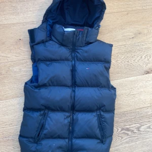 Svart  Tommy Hilfiger väst - Svart Tommy hilgiher väst En tjock dun väst från Tommy hilfiger i storlek S Den är inprinsip oanvänd och i bra skick, kan hämtas i Stockholm& Täby.