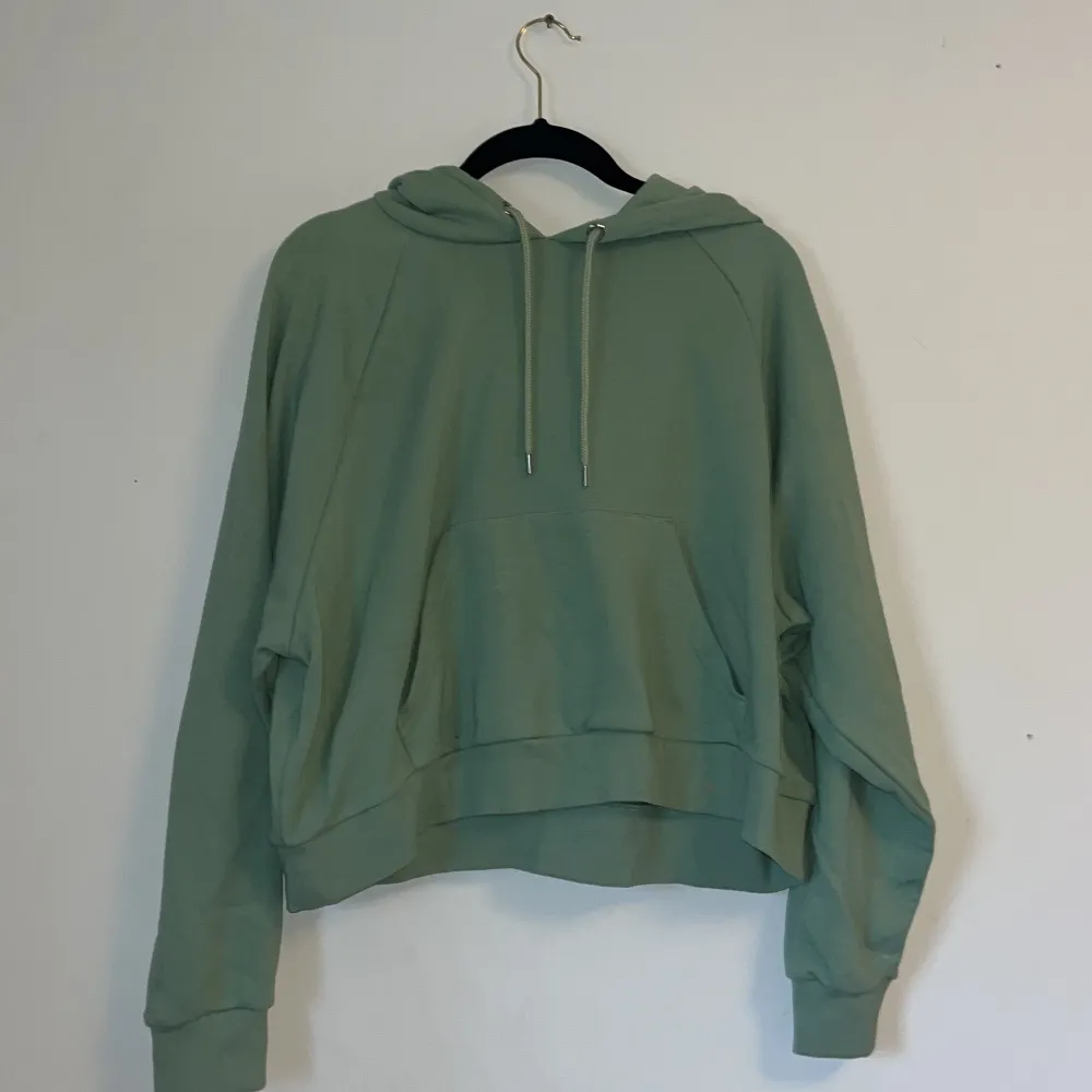 En grön hoodie som inte har några tecken på användning.. Hoodies.