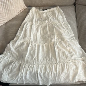 Lång kjol  - Lång vit kjol från Brandy Melville cirka 90cm lång.💓  Använd en gång. Ett par små fläckar på baksidan av kjolen (bild kan jag skicka vid behov)😊Står ingen storlek men kläder från Brandy Melville brukar säljas som onesize.  