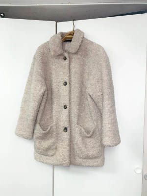 Teddy Jacka från Urban Outfitters - Trendig teddyjacka  Se bild 3 slitage under kragen varav det låga priset. Nypris ca 1000kr