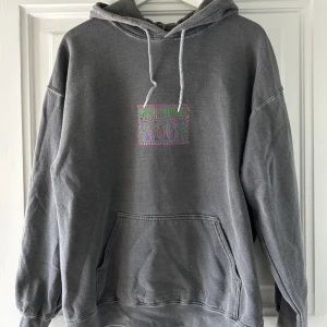 Hoodie - En grå hoodie med ett coolt tryck på ryggen, men även ett tryck där fram! Köpt second hand och därav vet jag inte märket. 