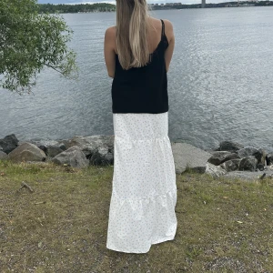 Långkjol blommig - En vit blommig långkjol som är handsydd. Det finns tre exemplar av kjol i olika storlekar och längder. 1 M & 2 XS/S  Skriv privat för mer ingormation om längd, mått & bilder. GRATIS FRAKT!!