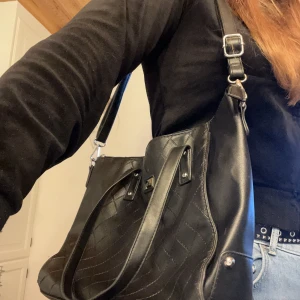 Väska mellanstor - Svart mellanstor väska med både handtag och axelrem. Fint skick. Längd:40 cm Höjd:28cm Bredd:16cm