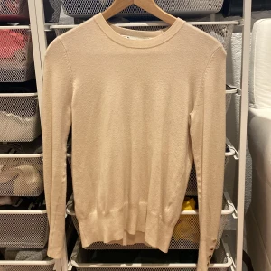 Stickad tröja  - En jättefin ljusrosa/beige stickad tröja från Zara med guldknappar längst nere på ärmen.