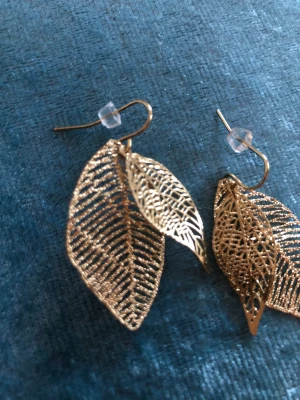 Guld löv - Ett par oanvända örhängen i form av två blad / löv. Ca 3 cm långa