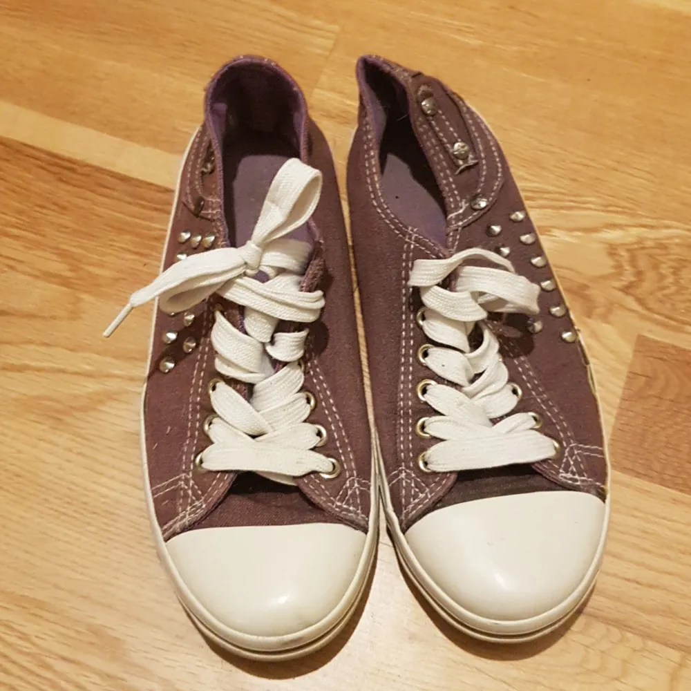 Lila converse med taggar på . Skor.