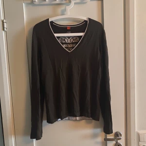 Grön långärmad  - Mörkgrön med vita detaljer. Okänt material. 