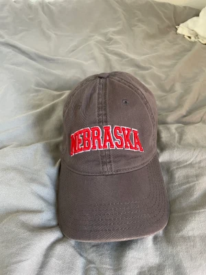 Vintage Nebraska keps  - Vintage Nebraska keps från Legacy i fint skick.☀️☀️ Justerbara spänne där bak så man kan ändra storleken. Bara att fråga om du undrar någonting. Kunden betalar frakt! 😁 