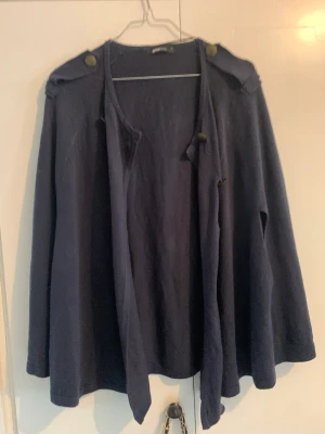 Poncho  - Poncho storlek S från Gina. Kan bäras knäppt eller hängandes på axlarna som en klassisk poncho. 