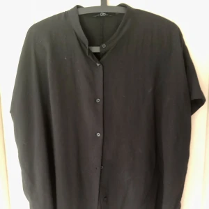 Blus, skjorta, topp  - Svart skjorta i viskos från Uniqlo. Knappt använd. Väldigt behagligt material och snyggt fall. Kan både kläs upp och användas vardagligt.