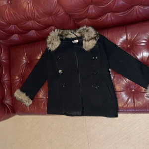 Blusa/jacka/kofta - En svart jacka/kofta/blusa med knappar och päls,finns fickor.