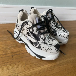 Buffalo London platåskor ko skinn - Buffalo skor storlek 39 använda 1 gång. Dalmatin/koskinn (det är riktigt skinn och mocka) 