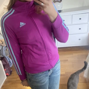 Adidas tröja - Snygg adidas zip!! Den är lila med turkos logga o ränder. Köpte på plick men inte blivit använd av mig.💗