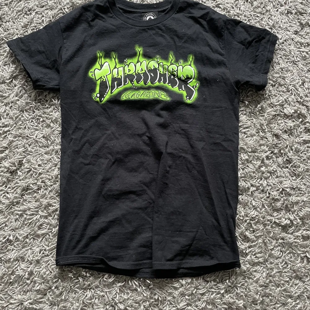 En grön och svart Trasher t shirt i storlek s. T-shirts.