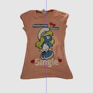 Rosa t-shirt  - Tryck där det står ”relationship status : single” med smurfan på 🫶väldigt söt och snygg 🫶