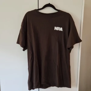 T-shirt, retro - Köpt från Beyond Retro, "NRA"-tryck på framsidan, grafiskt tryck på rygg. Strl L