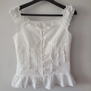Vacker vintage topp i bomull - Supersöt babydoll-liknande vintage topp i 100% bomull med söta pärlknappar. Går att ha ärmarna som vanlig eller off the shoulder. Säljer då den blivit lite för liten för mig, men annars är den en perfekt topp till sommaren!