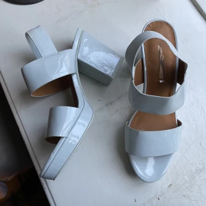 Babyblå klackar 40 - Babyblå / ljusblå klackskor med platå och lackad / glansig yta. Nästan helt oanvända! Och underbara! Storlek 40.   Finns att hämta i Gamla Stan och kan fraktas. 