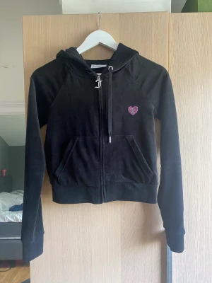 Juicy Couture  - Kortare hoodie från Juicy Couture. Inköpt på nelly.com. Endast använd 3-4 ggr i hemmet. Tröjan är i jättefint skick, som ny! Jättelen i tyget och bekväm. Storlek S. 500kr och då ingår frakt. 