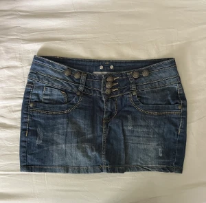 Mini jeanskjol - As snygg mini jeanskjol med tre knappar, från märket Monday Premium. Inga defekter! Storlek XS men passar även S! Midjemått mätt rakt över: 37cm, längd: 24cm 🫶💕