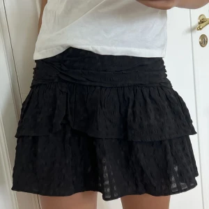 Svart volangkjol  - Svart volangkjol med svagt rutigt mönster, nypris 400