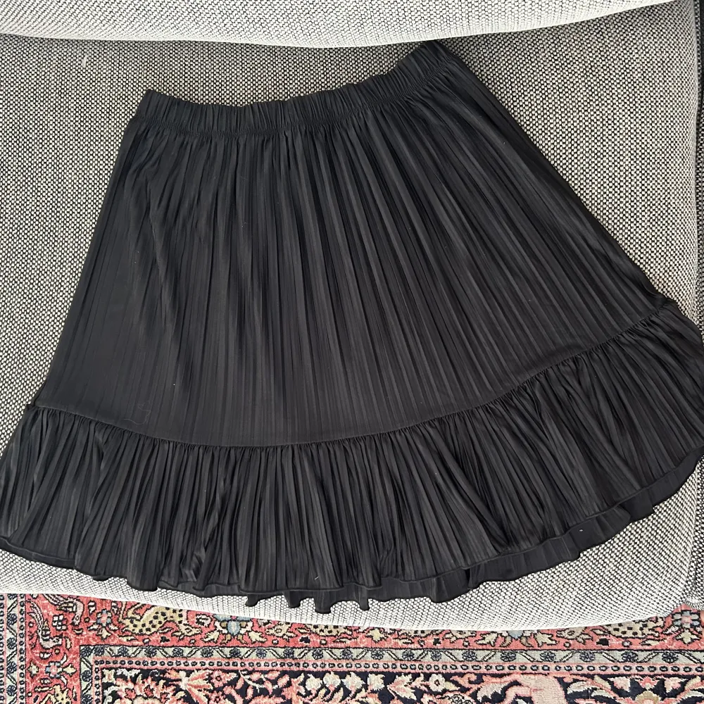 Zara svart plisserad kjol med volang längst ner. Väldigt bra skick, knappt använd. Stretchig så passar flera storlekar. . Kjolar.