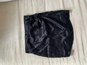 Satin kjol - Strl 34, andra bilden visar detaljen på kjolen. Aldrig använd