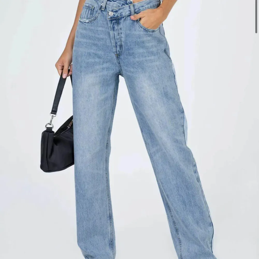 HOLLY ASYMMETRIC STRAIGHT LEG LIGHT WASH - helt nya jeans från princess polly säljer då jag köpt fel  stolek. Super snygg och sköna, haft likadana innan och älskar dem men köpte nu i fel storlek. Köpta för 1000kr (inkl tull & frakt). Pris kan diskuteras:). Jeans & Byxor.