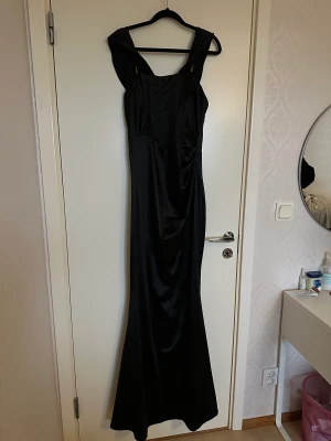 Långklänning - Perfekt för bröllop, bal samt fester. Använd en gång! Helt ny inga fel! Svart i storlek M, stretchig av sig, kan passa som S också!