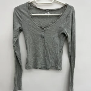 Hollister topp - Söt hollister topp i jätte skönt material. Sitter fint runt bysten. Är storlek XS men passar även S då den är väldigt töjbar!  Använd sparsamt och bra skick. 