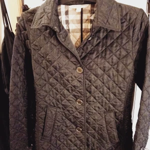 BURBERRY JACKA, BRIT - BURBERRY JACKA svart BRIT, QUILTAT TYG originalfoder, storlek Small. Superskön att ha på promenad både höst och vår. Även bra som sommarjacka.  Säljer den snabb affär 1200kr annars 1500kr