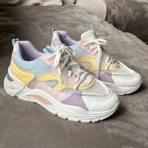 Sneakers - Fina sneakers i pastellfärger, använda endast en gång då de var  för små. Storlek 40 men små i storleken, så passar någon som har 39. Lila, ljusblå, rosa och gula med vit snörning. 
