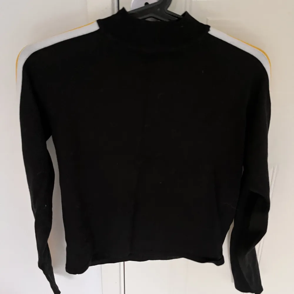 Tunn svart stickad tröja med gula och vita ränder på armarna🤍 Från H&M Storlek S Använd 2-3 gånger . Tröjor & Koftor.
