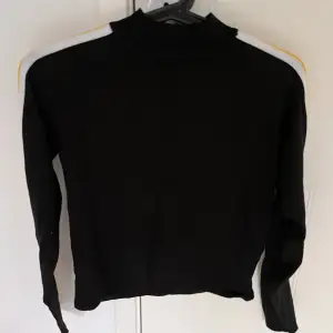 Tunn svart stickad tröja med gula och vita ränder på armarna🤍 Från H&M Storlek S Använd 2-3 gånger 