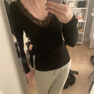 Långärmad spetstopp - Svart snygg tröja med spets. ribbad, materialet är ganska tunt, men väldigt bekväm, känns nästan lite som en träningströja. den är v-ringad både fram och bak. intimissimi liknande🤍 