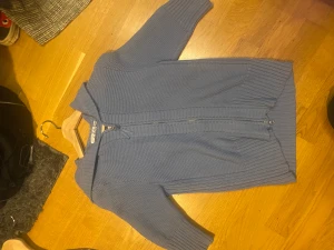 Trekvartshoodie - En blå trekvarts stickad hoodie