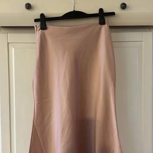 En rosa kjol som är medellång till mig som är 163cm lång, från NA-KD storlek 36