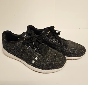 Munda:rt sneakers  - Sneakers från tyska märket Munda:rt. Nya, men har stått dammigt. Har inte försökt tvätta dem utan de säljs i befintligt skick och går säkert att piffa till mer. Sula i memory foam. Svarta men glittrar subtilt i alla olika färger likt bild 1.  Nypris 699 k