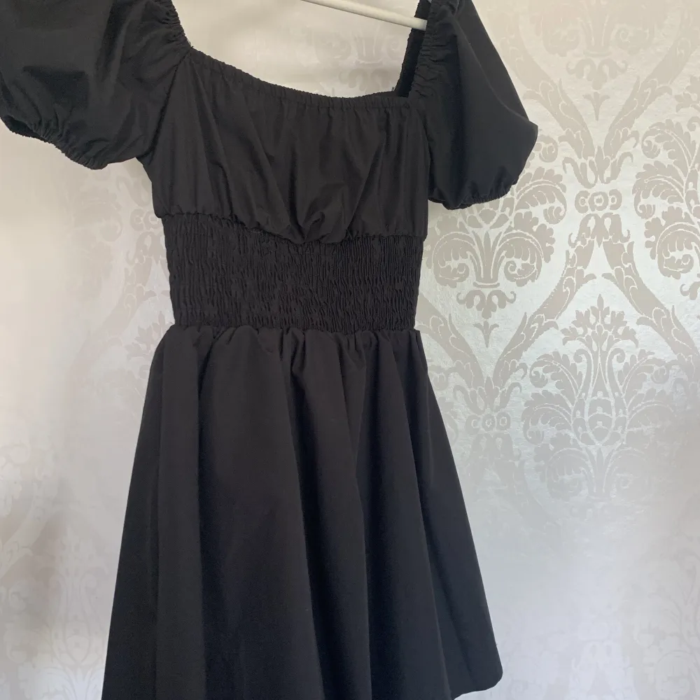 Säljer denna supersöta svarta klänningen med puffiga ärmar! Aldrig använd och är i nyskick💕. Klänningar.