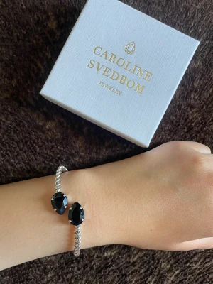 Caroline Svedbom armband  - Caroline Svedbom armband i silver med graphit kristaller, rostfritt. Det är även justerbart och passar därför alla. Ord pris 695kr🫶🏼