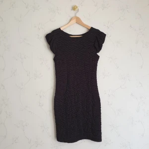 Svart bodycon popcorn dress  - ☀️FÖRST TILL KVARN!☀️ Svart bodycon dress med det trendiga popcorn tyget. Ärmarna är korta men sydda på ett sätt så att man kan ta på sig klänningen på två olika sätt. Klänningen är kort och kommer ungefär till låren, över knänen.