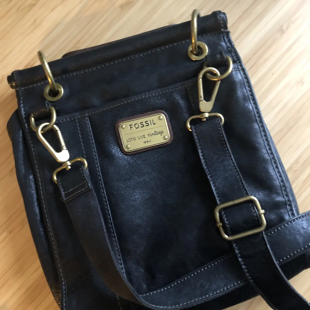 Original Fossil vintage series, leather bag. It can be carried in hand or used as cross body or shoulder bag. Beautiful brass details, very good condition. Measurements Width:20 cm Height:23 cm Depth:7,5 cm. Väskor.