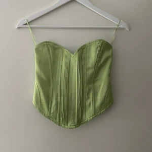 Grön Korsett - En snygg grön korsett med dragkedja i ryggen. Köpt på Bershka men har aldrig riktigt använt den! 